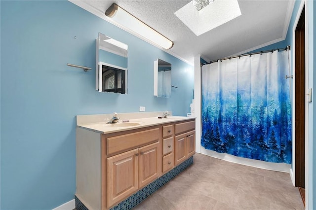 bathroom featuring vanity, a textured ceiling, a skylight, and ornamental molding