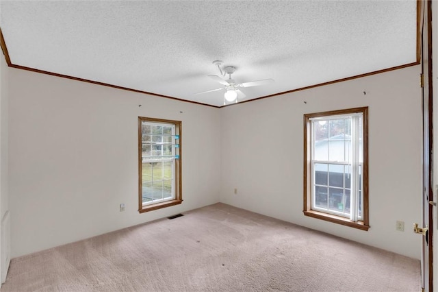 unfurnished room with crown molding, visible vents, a ceiling fan, light carpet, and a textured ceiling