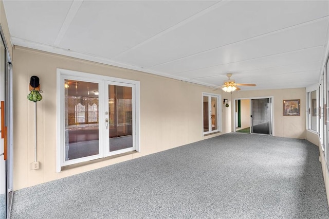 unfurnished sunroom featuring ceiling fan