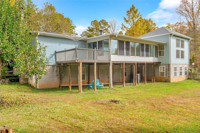 rear view of house featuring a sunroom and a yard