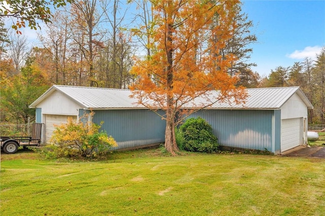 exterior space featuring an outbuilding, a front yard, and a garage