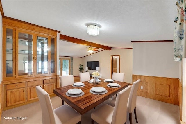 carpeted dining area featuring ceiling fan, crown molding, and lofted ceiling with beams