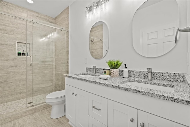 bathroom with walk in shower, vanity, and toilet