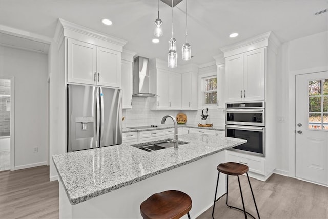 kitchen with white cabinetry, sink, wall chimney exhaust hood, and stainless steel appliances