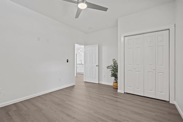 unfurnished bedroom with ceiling fan, a closet, and light hardwood / wood-style flooring