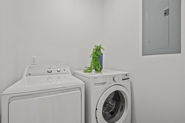 laundry room featuring electric panel and separate washer and dryer