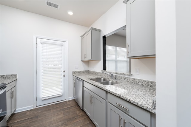 kitchen featuring dark hardwood / wood-style floors, gray cabinets, light stone countertops, sink, and dishwasher