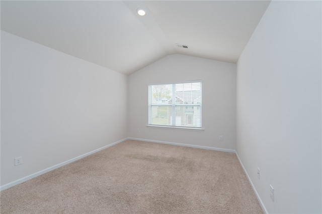 unfurnished room with light colored carpet and lofted ceiling