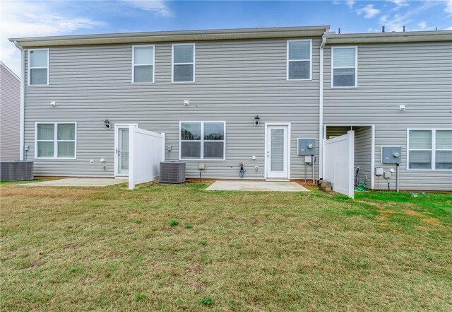 rear view of house featuring central AC unit, a lawn, and a patio