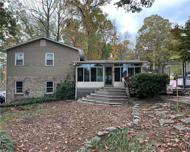 rear view of property featuring a sunroom