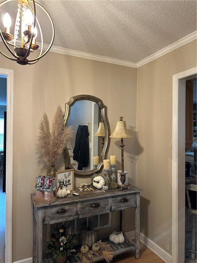 room details with ornamental molding, a textured ceiling, and an inviting chandelier