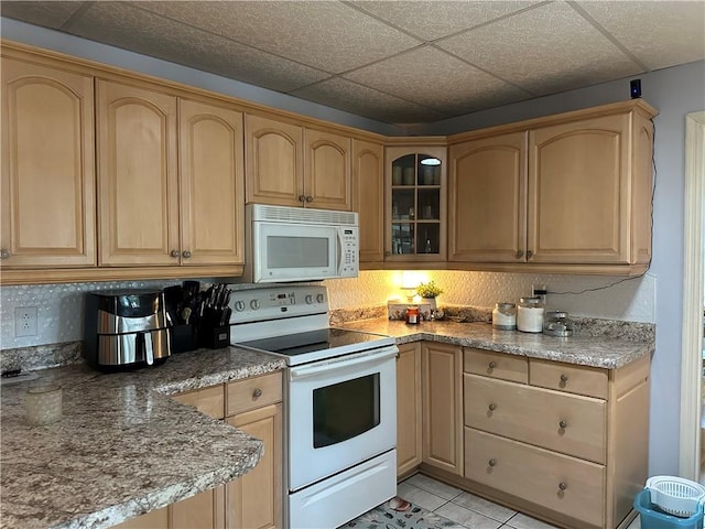 kitchen featuring light brown cabinets, white appliances, stone countertops, and light tile patterned flooring