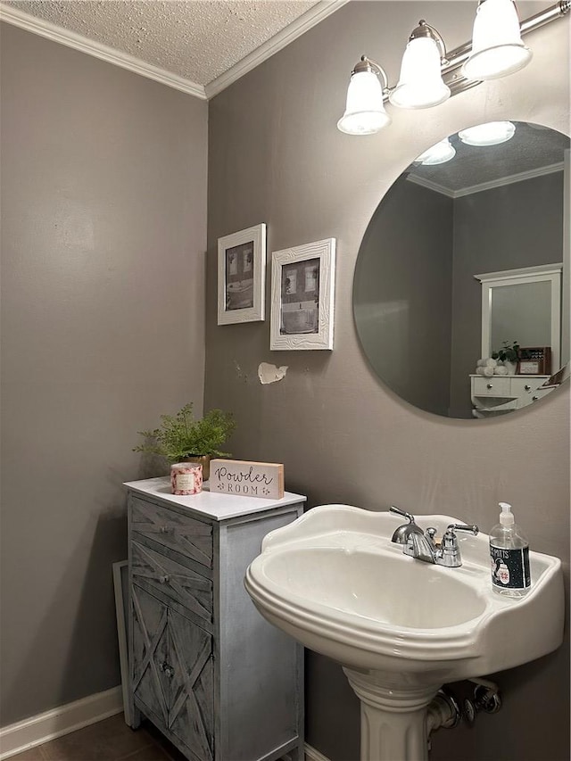 bathroom featuring sink, ornamental molding, and a textured ceiling