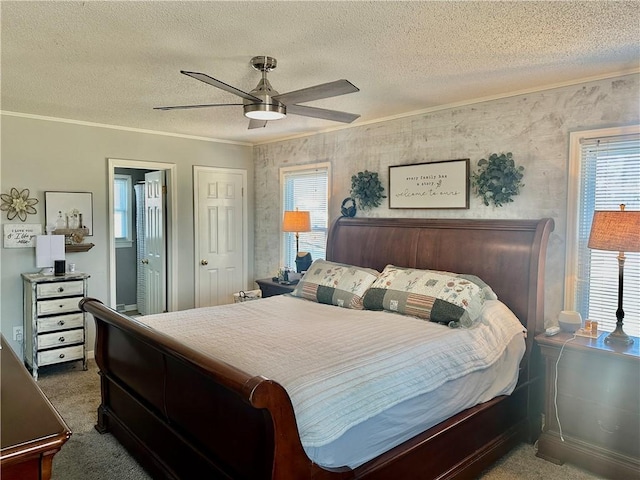 carpeted bedroom with a textured ceiling, ceiling fan, crown molding, and multiple windows