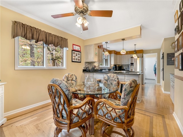 dining area featuring ceiling fan, sink, and ornamental molding