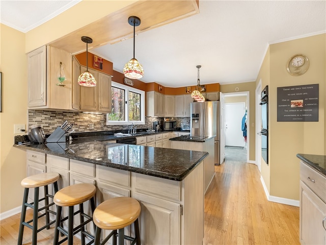 kitchen with light hardwood / wood-style floors, tasteful backsplash, a kitchen breakfast bar, decorative light fixtures, and a kitchen island