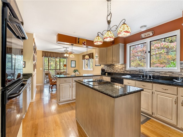 kitchen featuring sink, tasteful backsplash, light brown cabinets, decorative light fixtures, and a center island