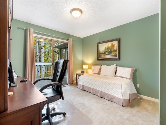 bedroom with light colored carpet and a textured ceiling