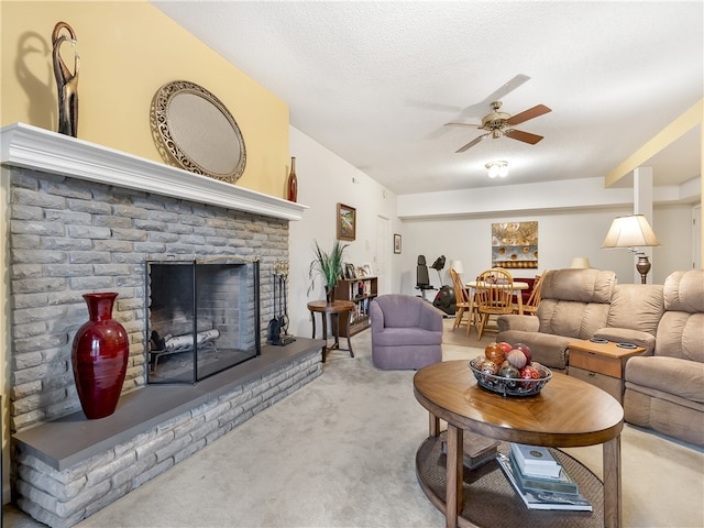 living room with a brick fireplace, carpet, a textured ceiling, and ceiling fan