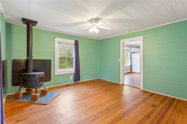 interior space featuring hardwood / wood-style floors, ceiling fan, and a wood stove