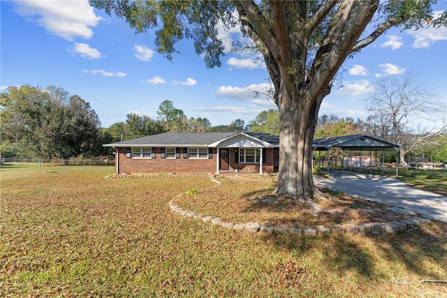 ranch-style home featuring a carport and a front yard