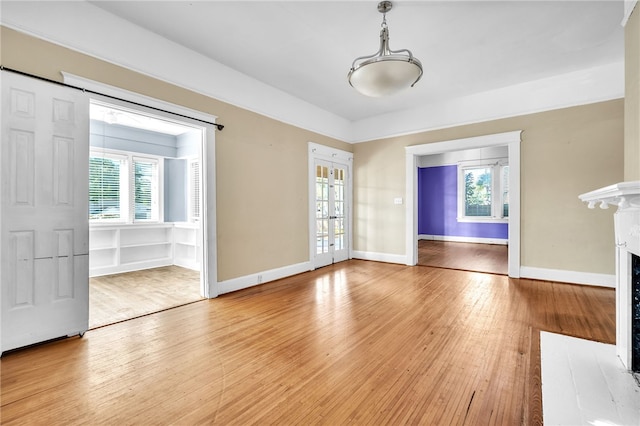 unfurnished living room with french doors, hardwood / wood-style flooring, and a fireplace