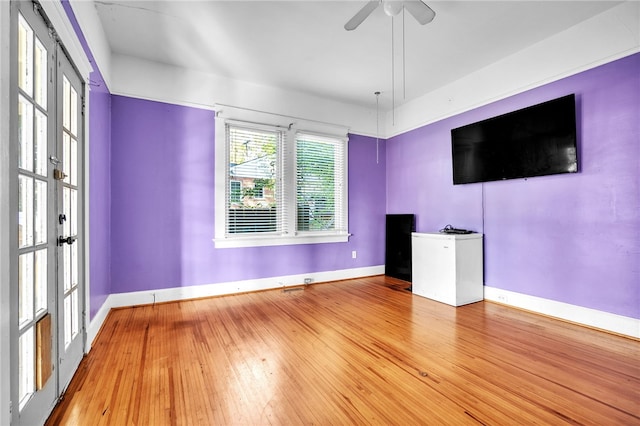 unfurnished living room featuring hardwood / wood-style floors, ceiling fan, and french doors