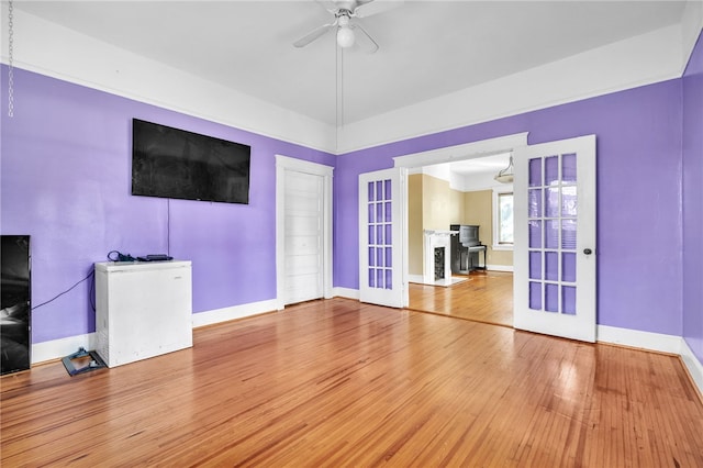 unfurnished living room with ceiling fan, wood-type flooring, and french doors