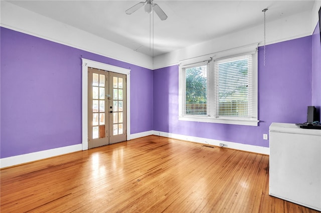 interior space with hardwood / wood-style flooring, ceiling fan, and french doors