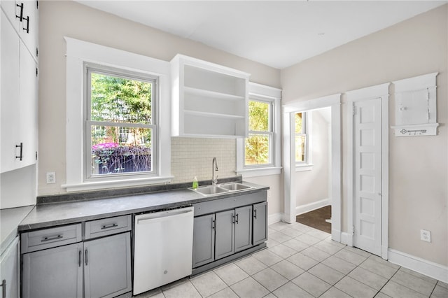 kitchen with gray cabinetry, light tile patterned flooring, backsplash, sink, and dishwasher