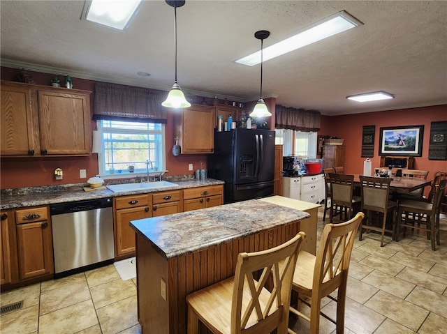 kitchen with a kitchen island, black fridge with ice dispenser, hanging light fixtures, a breakfast bar, and dishwasher