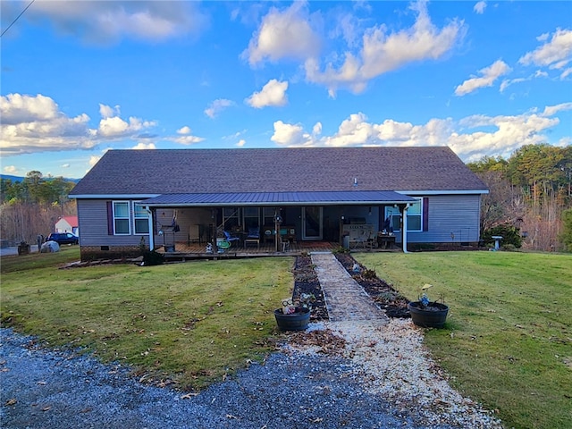 rear view of property featuring a yard and covered porch