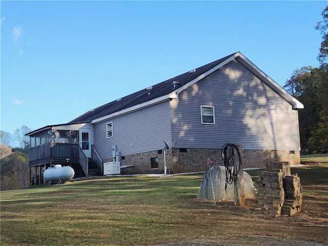 back of house featuring a lawn and a wooden deck