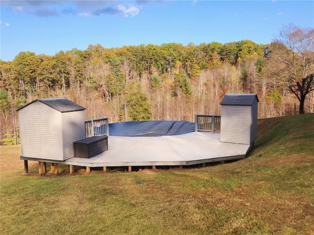 exterior space featuring a wooden deck, a storage unit, and a yard