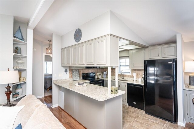 1230 Melton Rd Unit 31, West Union, SC 29696 - kitchen with black appliances, decorative backsplash, a peninsula, lofted ceiling, and light stone counters