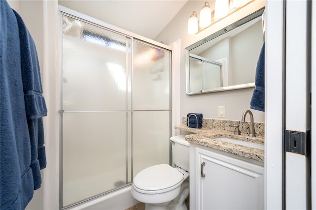 bathroom featuring lofted ceiling, toilet, vanity, and a shower with shower door