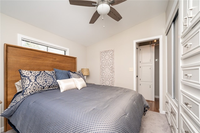 bedroom with ceiling fan, light carpet, a closet, and lofted ceiling