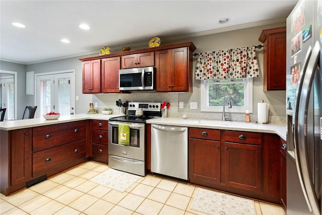 kitchen with appliances with stainless steel finishes, light tile patterned floors, crown molding, and sink