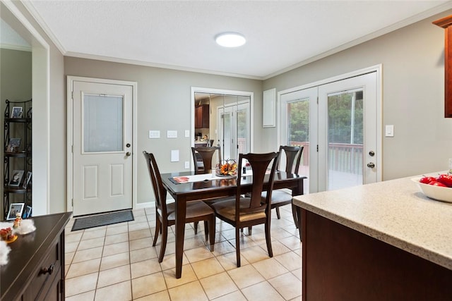 dining room featuring a textured ceiling, light tile patterned floors, crown molding, and french doors