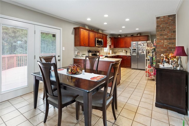 dining space with light tile patterned flooring and ornamental molding