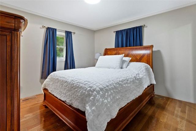 bedroom featuring hardwood / wood-style floors and crown molding