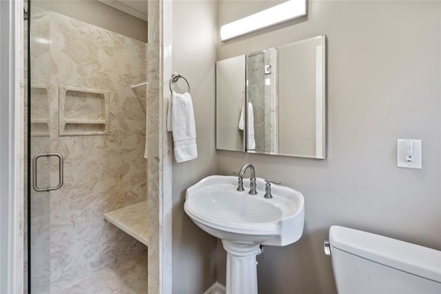 bathroom featuring a tile shower, toilet, and sink