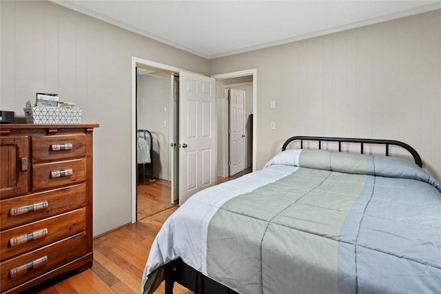 bedroom with crown molding and light wood-type flooring