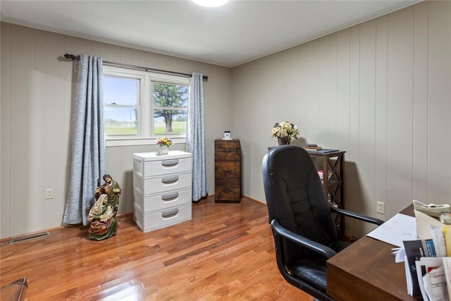 office space featuring wooden walls and light hardwood / wood-style floors