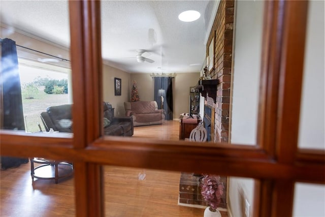 interior space with a fireplace, ceiling fan, hardwood / wood-style floors, and a textured ceiling