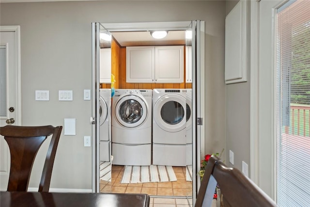 clothes washing area featuring cabinets, separate washer and dryer, and light tile patterned floors