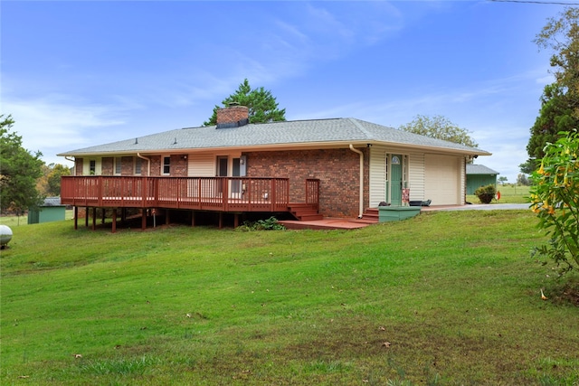 rear view of property with a lawn, a garage, and a deck