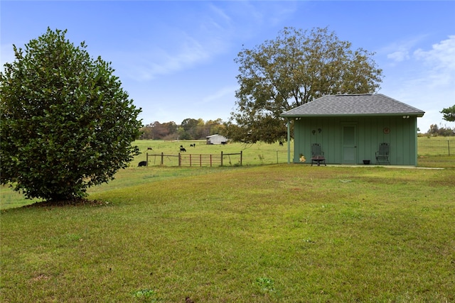 view of yard with a rural view and an outbuilding