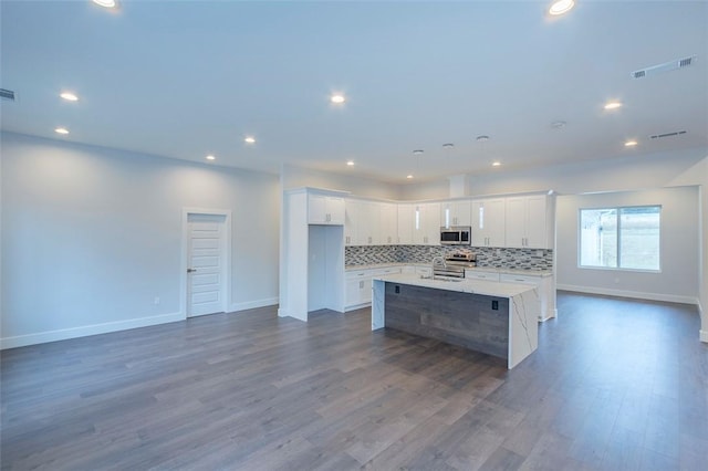 101 Tall Ship Dr, Anderson, SC 29625 - kitchen with baseboards, a center island, white cabinetry, tasteful backsplash, and appliances with stainless steel finishes