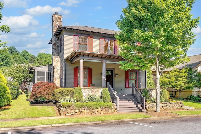 view of front of house featuring a sunroom and covered porch